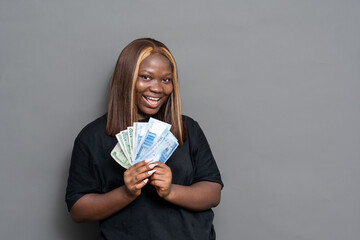 Beautiful young black woman holding some money and smiling