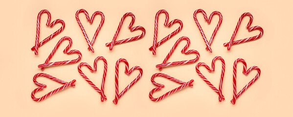 Hearts made of Christmas candy canes on yellow background