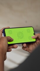 GREEN SCREEN CHROMA KEY A hand holding a smartphone with a green screen inside a renovated apartment