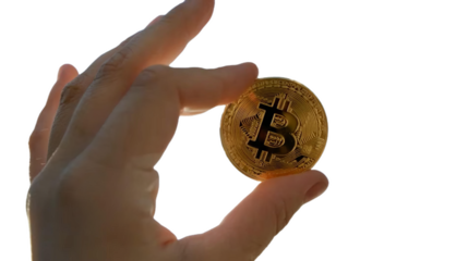 The image shows a close-up of a hand holding a physical representation of Bitcoin. The Bitcoin symbol "₿" in the center. You can place this background-removed PNG file wherever you like.