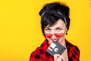 Saving data concept. Young brunette sexy woman with heart shape red glasses holding floppy disk...