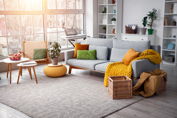 Interior of living room with grey sofa, armchair and shelf units