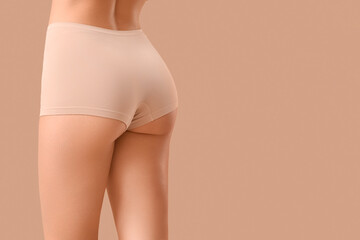 Pretty young woman in panties on beige background, closeup