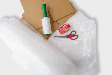 Packing Materials Flat Lay with Cardboard, Bubble Wrap, and Tape