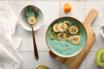 Bowl of tasty spirulina smoothie on tile background