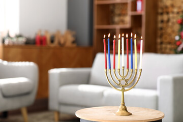 Menorah with burning candles for Hanukkah celebration on table in living room, closeup