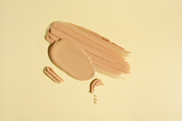 Composition with samples of liquid makeup foundation on color background
