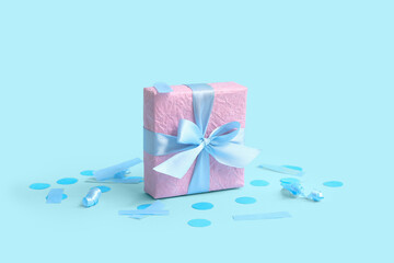 Pink gift box and confetti on blue background