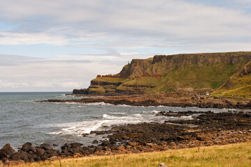 The ocean is calm and the shoreline is rocky