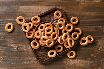 Bowl of tasty bagels on wooden background