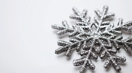Glittering silver snowflake decoration highly detailed placed on a pure white background for a minimalist winter theme