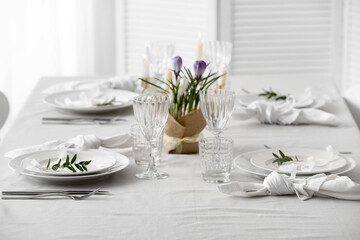 Table setting for Mother's Day celebration with beautiful flowers and burning candles in dining room