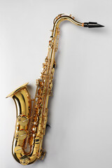Jazz. One saxophone on light grey background, top view