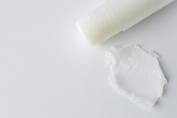 Stick of lip balm and sample on white background, top view. Space for text