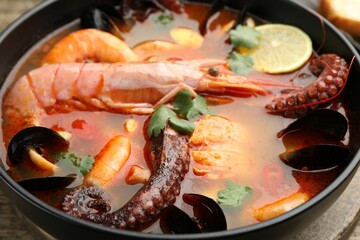 Delicious seafood soup in bowl on table, closeup