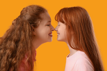 Beautiful young woman with her cute daughter on yellow background. Mother's Day celebration