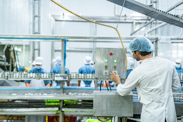scientist food processing plant supervisor examines industrial control systems, overseeing the production line to maintain high-quality standards and optimize the automated manufacturing process.