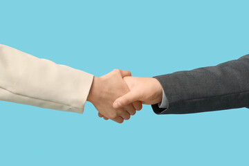 Business people shaking hands on blue background