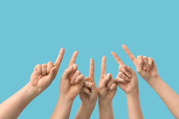 Many hands pointing up on blue background