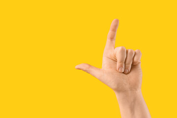 Male hand pointing up on yellow background