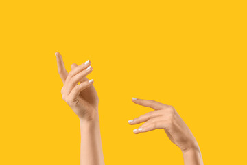Female hands on yellow background