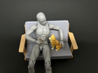 ソファの上で柴犬を抱き寄せる人形