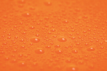 Macro photo of orange plasticine with water droplets as a background. Abstract orange background.
