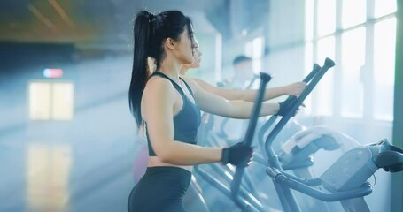 In a gym, many people actively exercise on ellipticals as part of their fitness routine