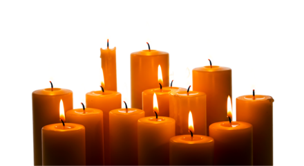 Group of lit candles with orange wax and flickering flames against a dark black background studio shot