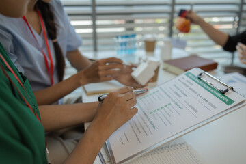 the three doctors are meeting to exchange new knowledge and information they have gained form their medical seminars with each other, a senior doctor is explaining information and knowledge