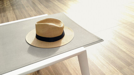 Sunbed with a hat on a sunny day. Outdoor lounger for relaxation. Freshness and bright summertime vacation.