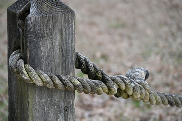 Worn Rustic Nautical Rope Through Hole in Wood Post Aged Texture Closeup Macro Texture