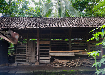 A rustic livestock shelter for cows or goats, surrounded by lush greenery and trees. a simple yet vital space for livestock care in the countryside