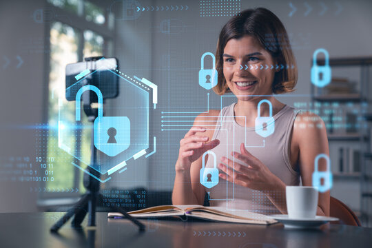 Happy woman is making video blog using smartphone on a tripod explaining with hands at office workplace. Concept of online stream, business education, conference call. Lock icons hologram