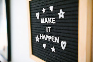Black wooden felt board on a white wall with a message that says 