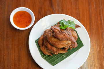 Deep fried chicken wings crispy and delicious thai sweet sauce on a wood table
