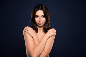 Fototapeta premium Portrait of a Beautiful Young Woman Posing Elegantly Against a Dark Blue Background