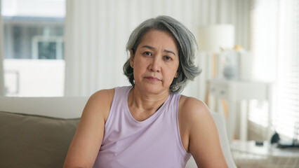 Asia adult boring people middle age old woman sit angry at sofa home anger hot flash elder mental...