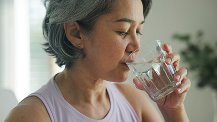 Asia adult people middle age happy old woman smile look at camera drink water stay hydrated reduce...