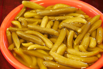 Pickled vegetables displayed in a bright bowl at a market stall