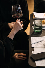 Person evaluating wine aroma with glass in hand during tasting session. Wine appreciation, experience design, sensory branding