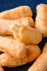Delicious venezuelan tequenos with melted cheese filling on a blue plate