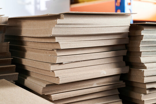 Thick paperboard stacks ready for production in a warehouse for eco-friendly cardboard box manufacturing