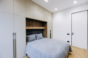 A cozy modern bedroom with an elegant minimalist design and warm tones for a welcoming feel