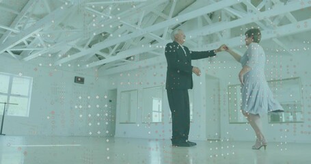 Elderly couple dancing in bright room with digital data animation overlay