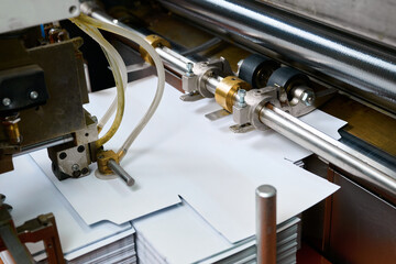 Innovative paper feed mechanism gliding smoothly in a modern glue spreading machine at a factory setting