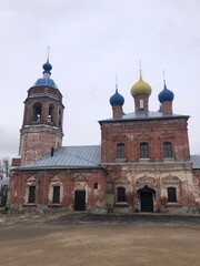 Fototapeta premium old brick church with blue and golden domes in winter, showcasing Russian architecture and historical religious building design for travel, tourism, or educational content