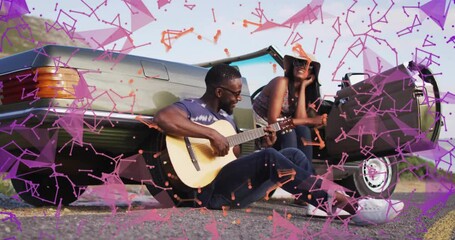 Man playing guitar next to car with colorful geometric animation overlay - Powered by Adobe
