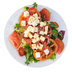 Crisp and refreshing colorful salad, perfect for dinner, with mix of lettuce, sliced tomatoes, onion, olives and cheese, served on white plate. Isolated over white background