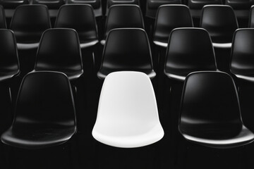 Naklejka premium Single white seat amongst black seats in empty stadium